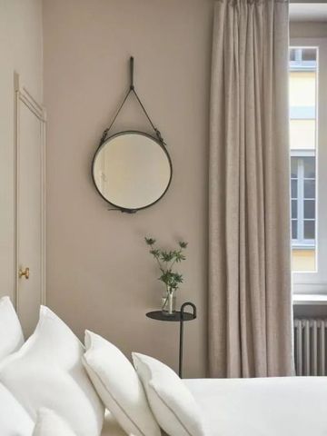 Elegante Zimmeransicht mit rundem Spiegel und sanften Vorhängen