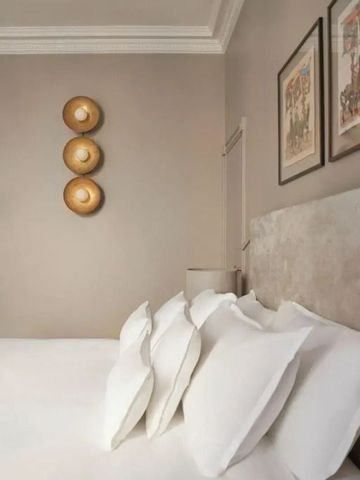 Luxuriöses Schlafzimmer mit Kunst an der Wand und hochwertigen Kissen