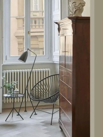 Leseecke mit Stuhl und Stehlampe in Hotelzimmer mit Blick nach draußen.