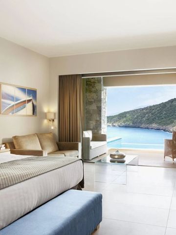 Luxuriöses Zimmer mit Meerblick, großem Bett und stilvoller Einrichtung.