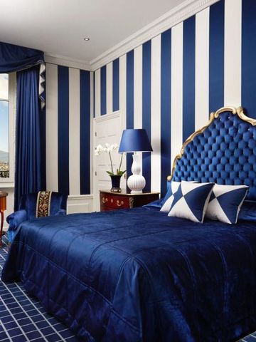 Luxuriöses Hotelzimmer mit blau-weißem Dekor und gepolstertem Bettkopfteil