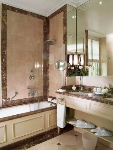 Luxuriöses Badezimmer mit Marmorelementen und eingelassener Badewanne