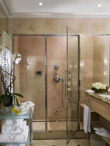 Moderne Dusche in einem eleganten Bad mit Blumen und Handtüchern