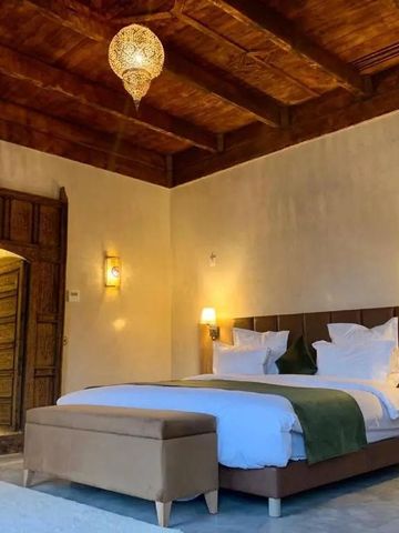 Geräumiges Schlafzimmer mit Holzdecke und elegantem Bett im Dar Hnini Hotel