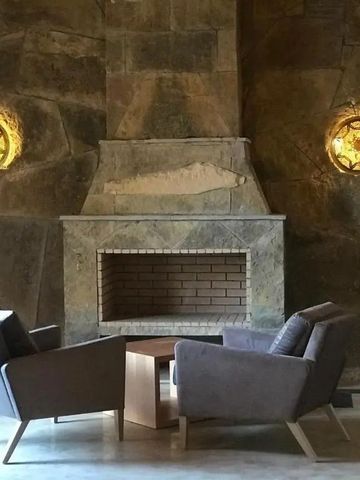 Gemütliche Lounge mit Steinkamin und stilvollen Sesseln im Hotel Dar Hnini