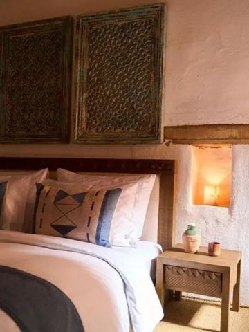 Hübsch dekoriertes Bett mit einzigartigem Wandkunstwerk im Hintergrund