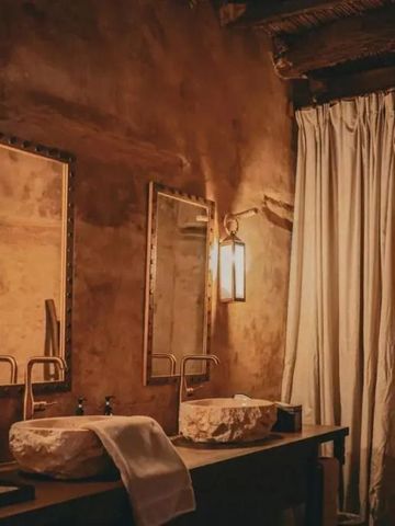 Doppelwaschbecken im rustikalen Badezimmer mit Spiegel und Beleuchtung