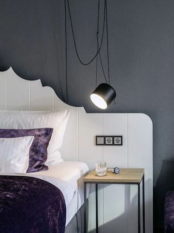 Stilvolles Zimmer mit modernen Hängelampen und violetten Details