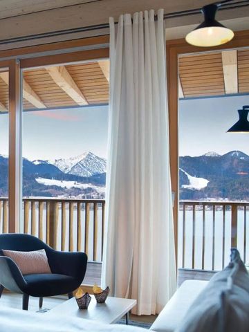 Elegant eingerichtetes Zimmer mit großem Fenster und atemberaubendem Blick auf verschneite Berge