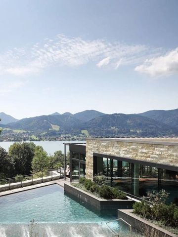 Infinity Pool mit Blick auf die Alpen und den Tegernsee bei sonnigem Wetter.