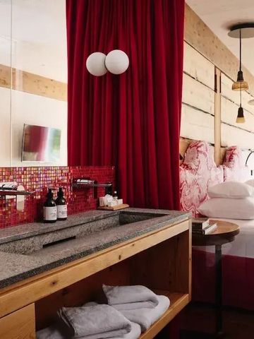 Luxuriöses Hotelzimmer mit rotem Vorhang und modernen Armaturen