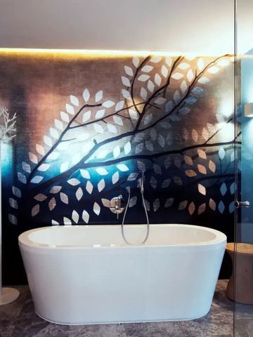 Elegantes Badezimmer mit freistehender Wanne und Baumdekor
