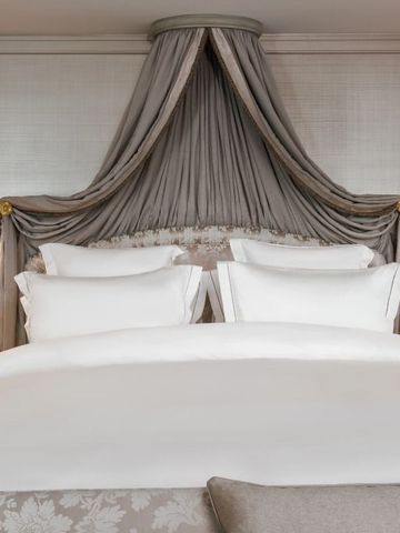 Exquisites Bett mit opulentem Baldachin in einer Hotelsuite