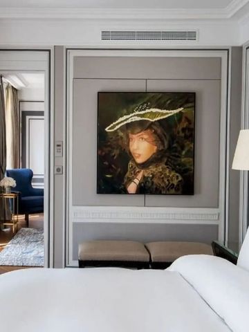 Elegantes Hotelzimmer mit Kunstwerk an der Wand und gemütlichem Sessel im Hintergrund