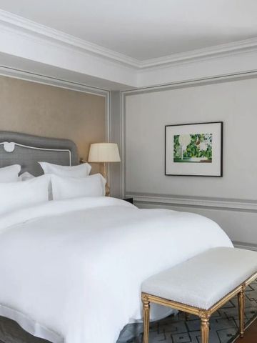 Luxuriöses Schlafzimmer mit großen Kissen und moderner Wandkunst