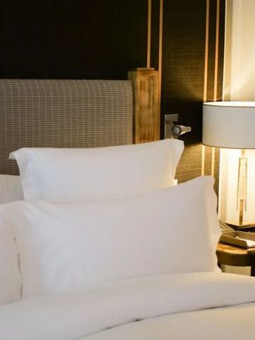 Modernes Hotelzimmer mit geschmackvoller Beleuchtung und edlem Kopfteil