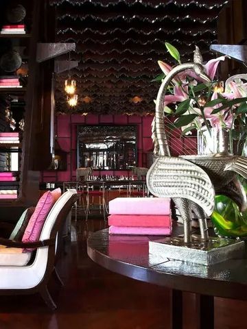 Stilvoll dekorierter Lounge-Bereich mit Kunstwerken und Blumenarrangement.