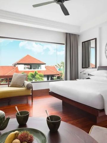 Helles Zimmer mit großem Fenster und Blick auf die rote Dachlandschaft.