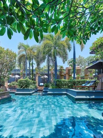 Tropischer Pool umgeben von Palmen