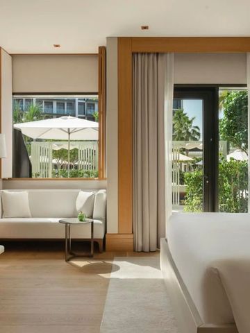 Hotelzimmer mit Terrasse und Blick auf einen grünen Garten