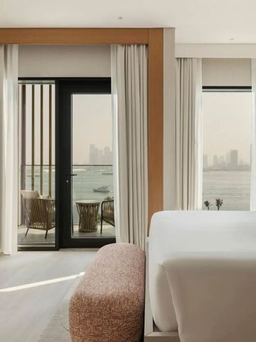 Luxuriöses Zimmer mit Blick auf die Skyline von Dubai durch große Fenster.