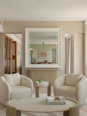 Gemütliches Wohnzimmer mit modernen Sesseln und elegantem Spiegel.