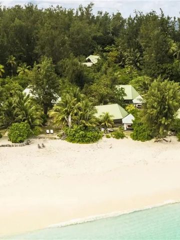 Strand mit tropischer Vegetation und Villen im Hintergrund