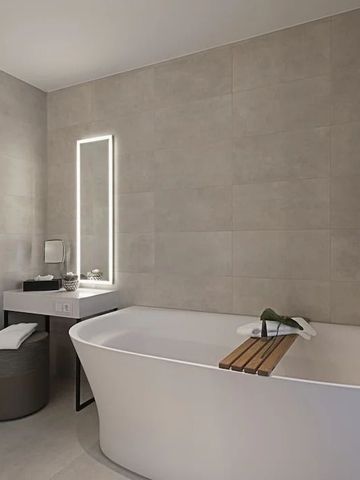 Modernes Badezimmer mit freistehender Badewanne und beleuchtetem Spiegel