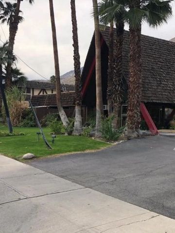 Eingang des Wolwedans Desert Lodge mit Palmen und grünem Rasen