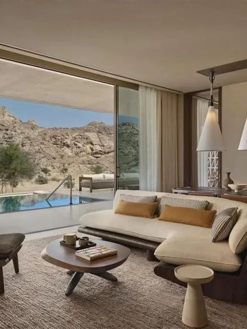 Geräumiges Wohnzimmer mit Blick auf Pool und Felslandschaft