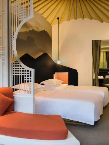 Doppelzimmer mit stilvollen Holz- und Stoffelementen sowie Wandkunst.