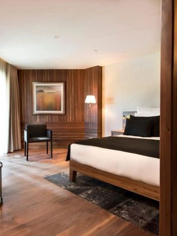 Geräumiges Hotelzimmer mit Holzelementen und stilvoller Einrichtung.