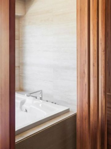 Luxuriöses Badezimmer mit Holzverkleidung und freistehender Badewanne