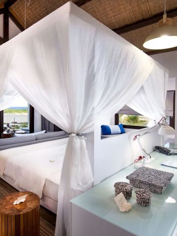 Luxuriöses Schlafzimmer mit Himmelbett und Blick auf das Meer