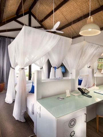 Geräumiges Schlafzimmer mit zwei Himmelbetten und moderner Einrichtung