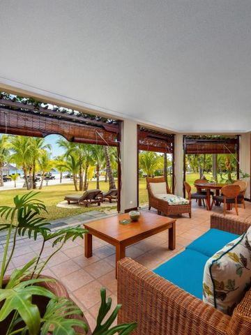 Terrasse im Dinarobin Beachcomber mit Blick auf Strand und Palmen.