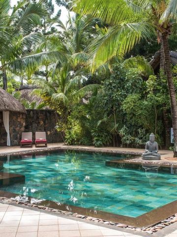 Kleiner Pool umgeben von Palmen und Buddha-Statue