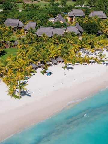 Strand mit Palmen und Villen im Hintergrund