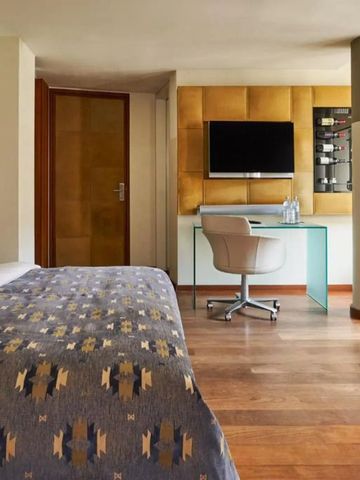 Geräumiges Hotelzimmer mit Schreibtisch, Fernseher und modernem Dekor