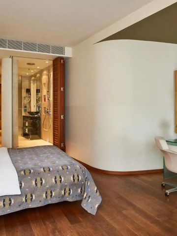 Helles Hotelzimmer mit Fernseher am Schreibtisch und modernem Bad