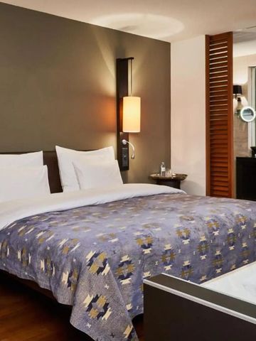 Modernes Hotelzimmer mit einem großen Doppelbett und stilvoller Beleuchtung