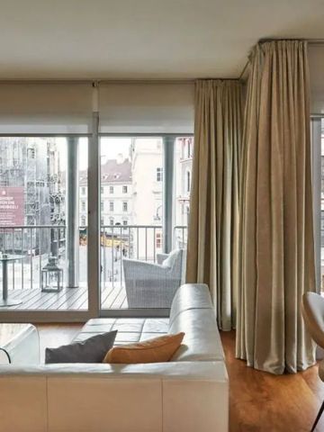 Helle Suite mit Fensterfront und Aussicht auf die Stadt. Bequeme Sitzmöbel