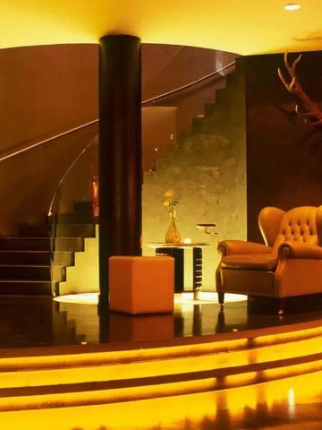 Luxuriös beleuchtete Lobby mit Wendeltreppe und stilvollem Sessel