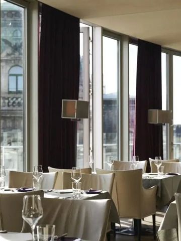 Feines Restaurant mit großer Fensterfront und Blick auf die Stadt