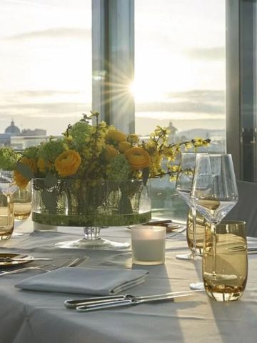 Eleganter Tisch gedeckt für Dinner mit Blumenarrangement bei Sonnenuntergang
