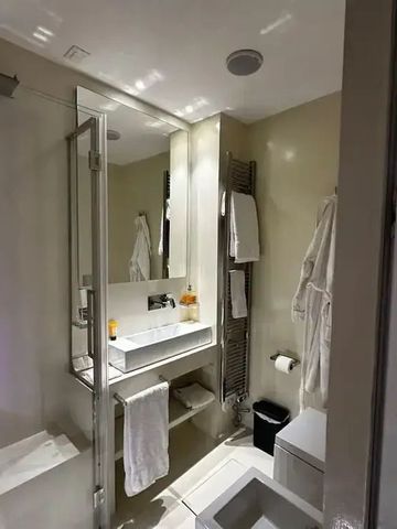 Modernes Badezimmer mit großem Spiegel und Dusche im Hotel.