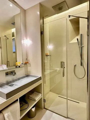 Elegantes Hotelbadezimmer mit großer Dusche und Doppelwaschbecken.