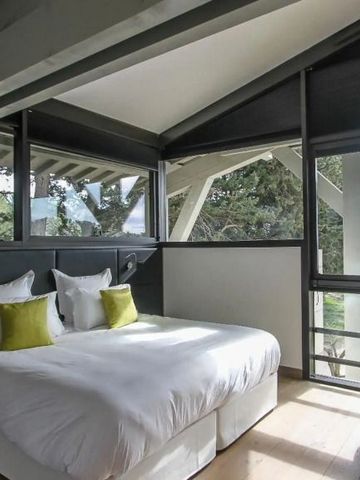 Helles Zimmer mit großer Fensterfront und Doppelbett in modernem Design