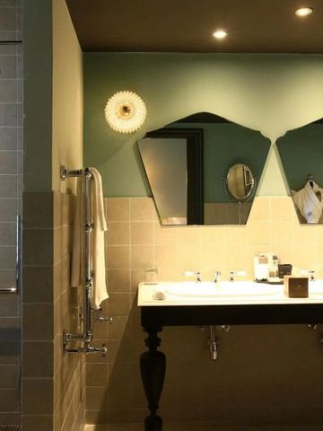 Stilvolles Badezimmer mit Doppelwaschbecken und geometrischen Spiegeln