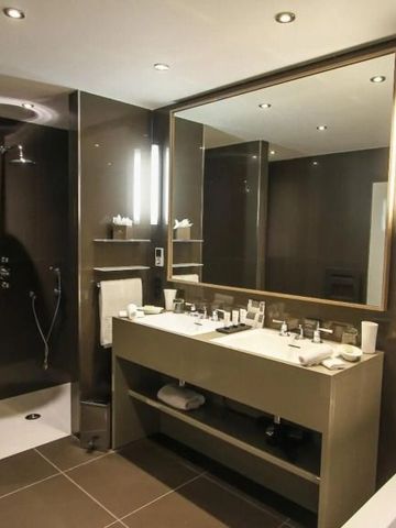 Modernes Badezimmer mit Regendusche und großer Spiegelwand